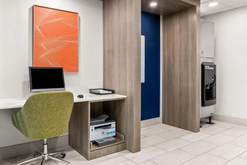 an office with a desk with a computer and a chair at Holiday Inn Express & Suites Detroit - Novi by IHG in Novi