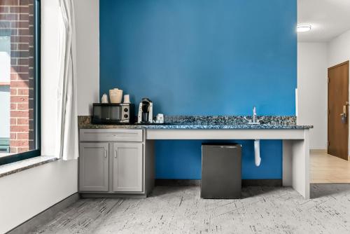 a kitchen with a counter with a blue wall at Holiday Inn Express & Suites Detroit - Novi by IHG in Novi