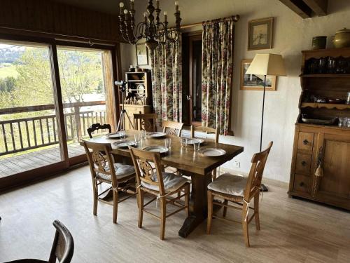 a dining room with a wooden table and chairs at Chalet Lombard - CHALET 10 PERSONNES MAE-2711 in Combloux
