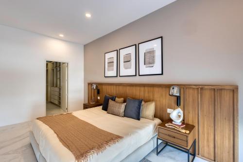 a bedroom with a large bed with a wooden headboard at Lumina at Marea Cabo San Lucas in Cabo San Lucas