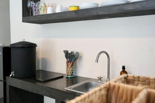 een aanrecht met een wastafel en keukengerei bij Casa Chayote Azul in Sayulita