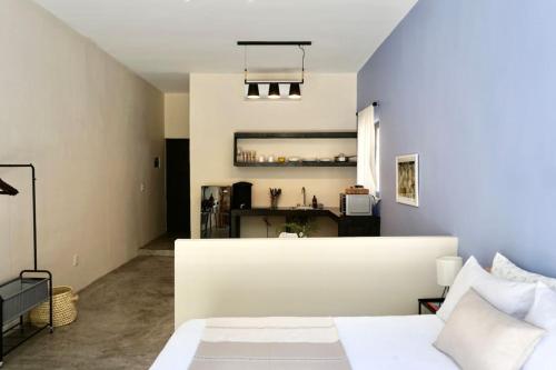 een slaapkamer met een wit bed en een keuken bij Casa Chayote Azul in Sayulita