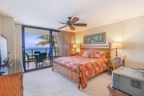 Un dormitorio con una cama y vista al mar. en Mahana 617, en Kahana