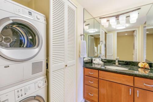 Un baño con lavadora y lavadora. en Mahana 617, en Kahana