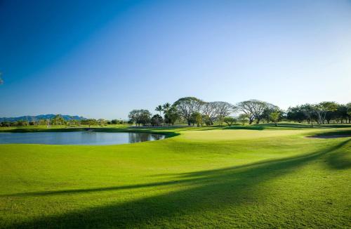 a view of a golf course with a pond at Grand Luxxe at Vidanta in Jarretadera