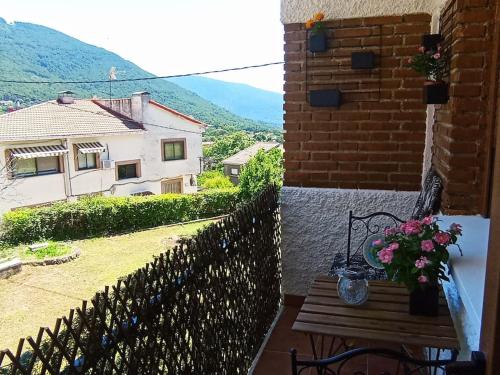 a view of a house with a bench and flowers at Precioso piso con increíbles vistas en Piedralaves, Tiétar in Piedralaves