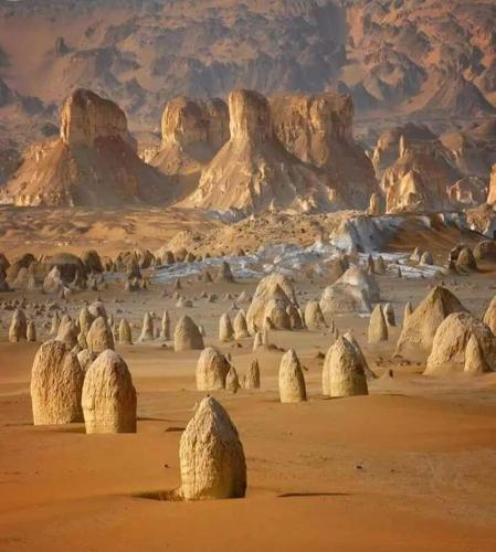 a desert with rocks and mountains in the distance at oasis panorama in Bawiti