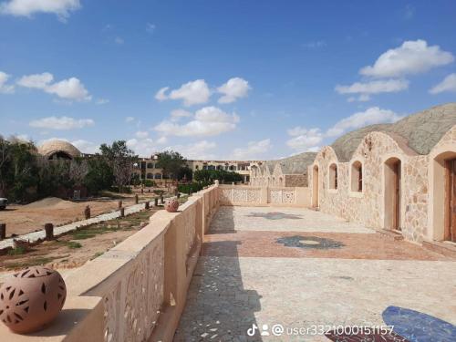a view of a building with mountains in the background at oasis panorama in Bawiti