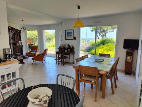 une cuisine et un salon avec une table et des chaises dans l'établissement Magnifique maison face à la mer, à Damgan
