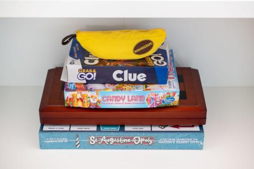 a stack of books with a bag on top of them at Coastal Condo - Walk to Beach Pool Pickleball and Boat Ramp in Saint Augustine