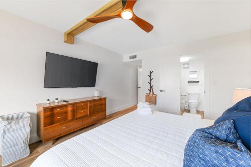 a bedroom with a bed and a flat screen tv at Coastal Condo - Walk to Beach Pool Pickleball and Boat Ramp in Saint Augustine