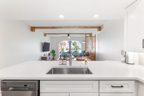 a kitchen with white cabinets and a sink at Coastal Condo - Walk to Beach Pool Pickleball and Boat Ramp in Saint Augustine