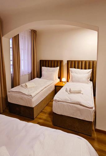 a bedroom with two beds and a mirror at Hotel Karlova Prague in Prague
