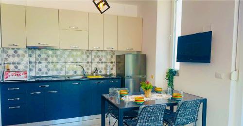 una cucina con armadi blu e tavolo con sedie di King Princ a Shëngjin