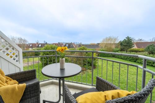 a patio with a table and chairs on a balcony at Küstenperle Nordsee mit Balkon und Sauna in Cappel-Neufeld