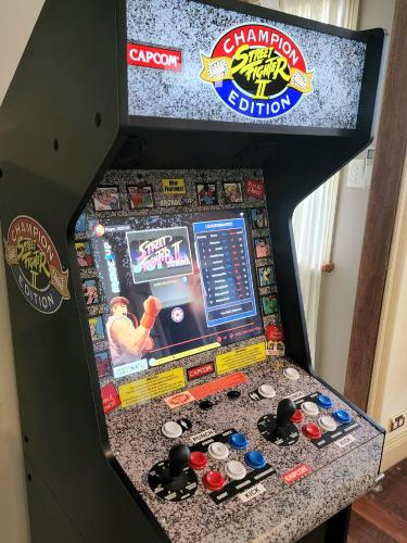 a pinball game in a game room with a game console at The Black Cockatoo - Secret Garden Treetops Home in Katoomba