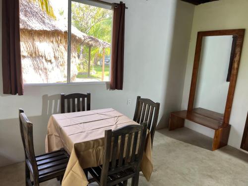 a dining room with a table and chairs and a window at Xanthus Hotel in Huay Pix