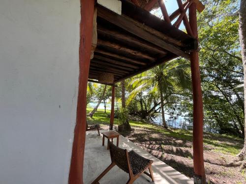 a porch of a house with two chairs and a table at Xanthus Hotel in Huay Pix