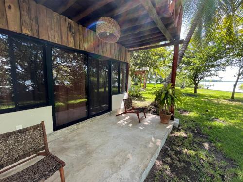 a screened in porch with a bench and a chair at Xanthus Hotel in Huay Pix