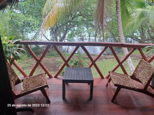 a porch with two chairs and a table on it at Xanthus Hotel in Huay Pix