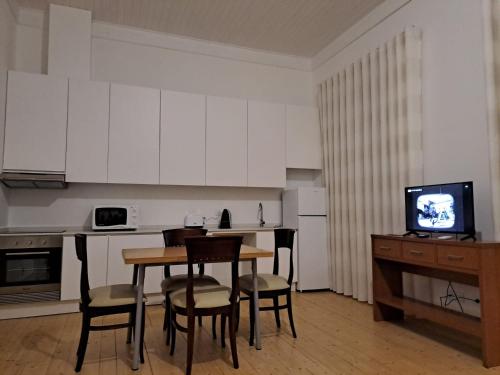 a kitchen with a table and chairs and a television at S Pedro Serta in Sertã