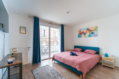 une chambre avec un lit et une grande fenêtre dans l'établissement Le Arty - 20 min de Paris et Orly, à Vitry-sur-Seine