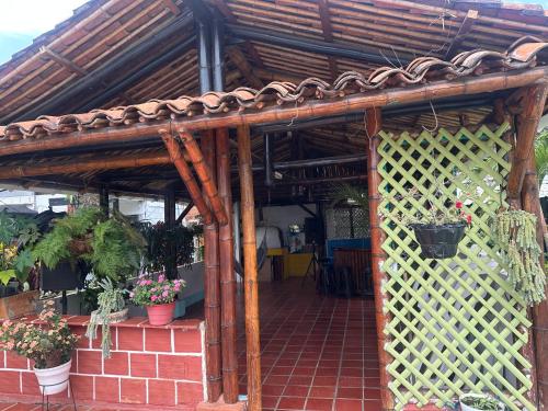 a wooden pergola with potted plants on it at Casa finca Reina in Santander de Quilichao