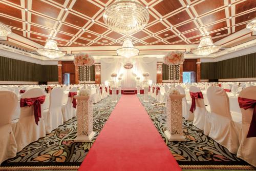 une salle de banquet avec des tables, des chaises et un tapis rouge dans l'établissement Army Hotel, à Hanoï