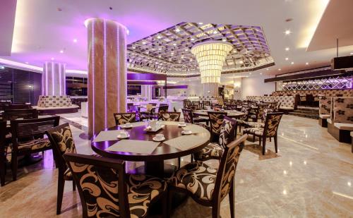a restaurant with tables and chairs with purple lighting at Army Hotel in Hanoi