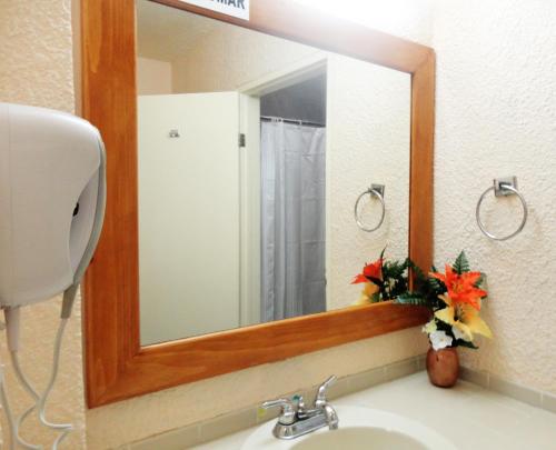 a mirror over a sink in a bathroom at Hotel Santo Tomas in Ensenada