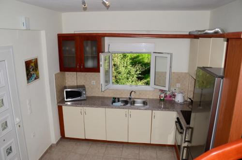 a small kitchen with a sink and a window at Villa Ektoras II by EY Villas in Parga