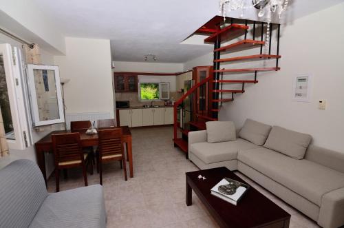 a living room with a couch and a spiral staircase at Villa Ektoras II by EY Villas in Parga