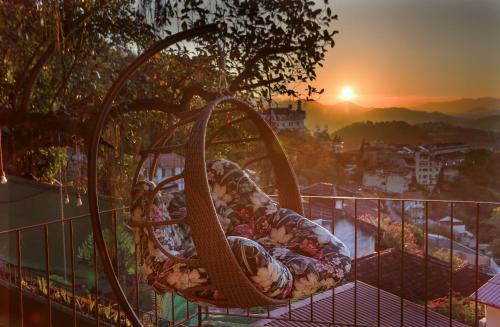 - un bébé sur une balançoire sur un balcon au coucher du soleil dans l'établissement Inn House Santa Teresa, à Rio de Janeiro