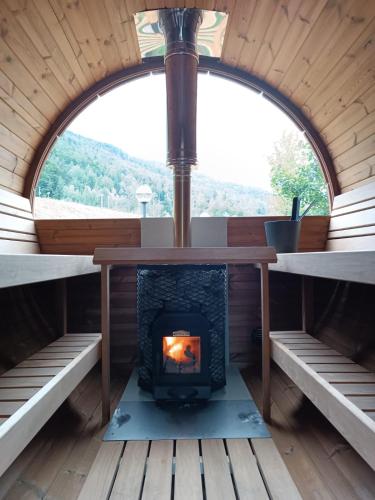 a fireplace in a cabin with a window at Albergo Boschetto Ristorante Pizzeria in Druogno