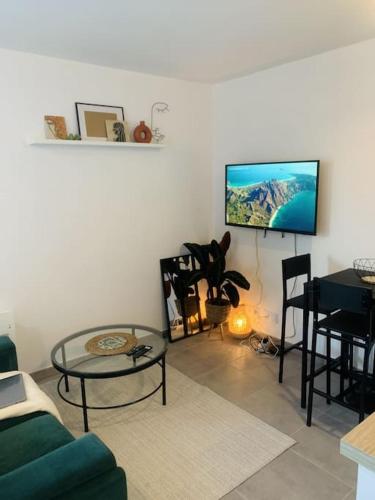 un salon avec un canapé vert et une table dans l'établissement Superbe Appartement avec parking sous sol gratuit, à Livry-Gargan