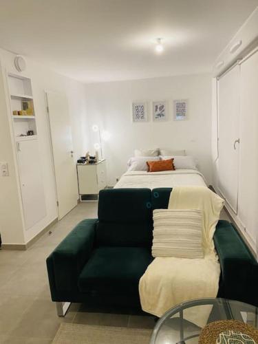 une chambre avec un lit et un canapé vert dans l'établissement Superbe Appartement avec parking sous sol gratuit, à Livry-Gargan