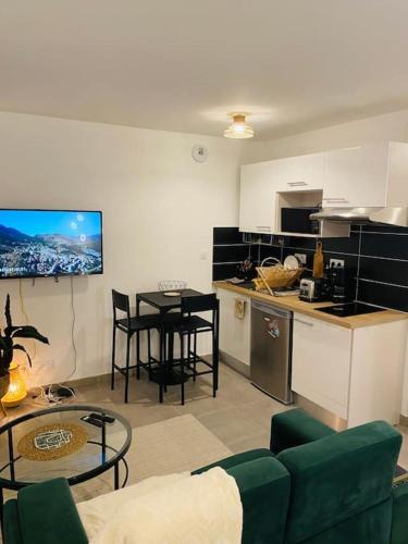 un salon avec un canapé et une cuisine avec une table dans l'établissement Superbe Appartement avec parking sous sol gratuit, à Livry-Gargan