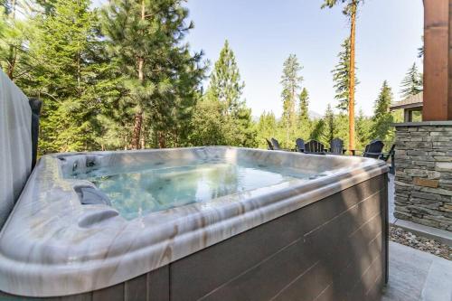 a jacuzzi tub on a patio with trees at Smore Days Plz in Cle Elum