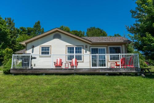 a house with a deck with red chairs on it at Blue Water Acres in Huntsville