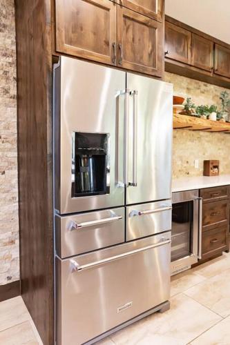 a stainless steel refrigerator in a kitchen with wooden cabinets at Smore Days Plz in Cle Elum