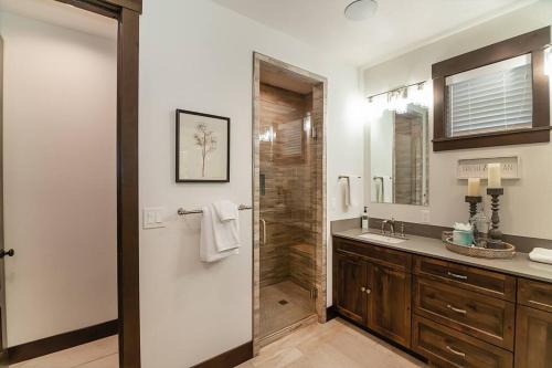 a bathroom with a shower with a sink and a mirror at Smore Days Plz in Cle Elum
