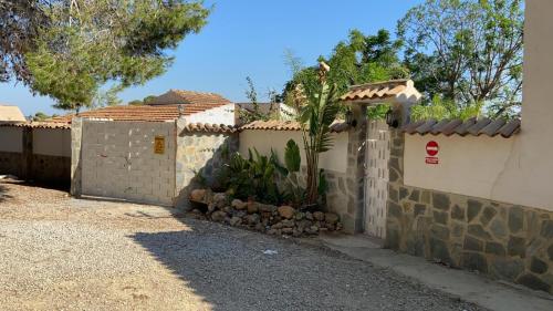 a white fence with a palm tree next to a house at Villas de encanto in Vilamarxant