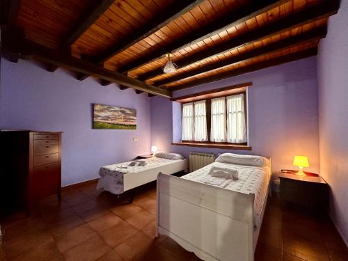 two beds in a room with purple walls at Kanala, estupendas vistas al Urdaibai in Canala