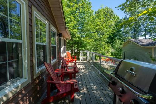 a deck with chairs and a grill on a house at Blue Water Acres in Huntsville