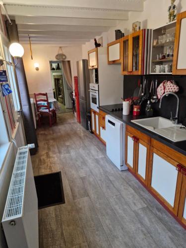 une cuisine avec un évier et un réfrigérateur dans l'établissement La Demeure de l'étrier - Baie de Somme - 12 personnes, à Acheux-en-Vimeu