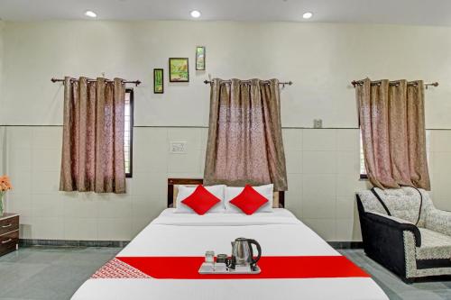 a hotel room with a bed and a chair at Hotel O Sunshine Inn in Nagpur