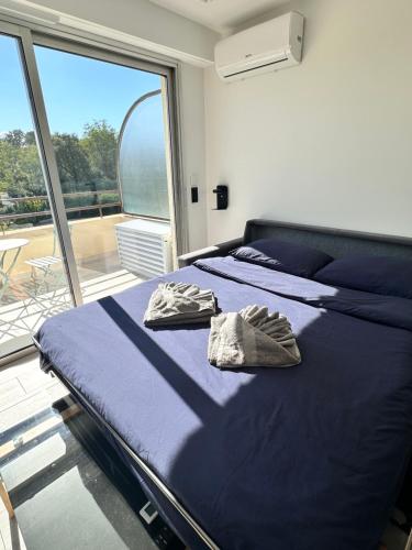 a bedroom with two beds and a large window at STUDIO HORIZON - SEA VIEW - POOL- Air Conditioner - Kitchen - Wifi -TV Train - Bus - in Villeneuve-Loubet