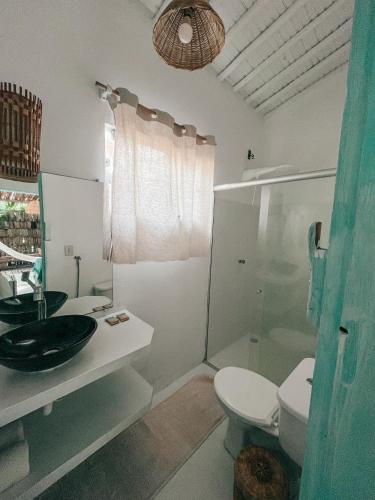 a bathroom with a toilet and a sink and a shower at Encanto Caraíva in Caraíva