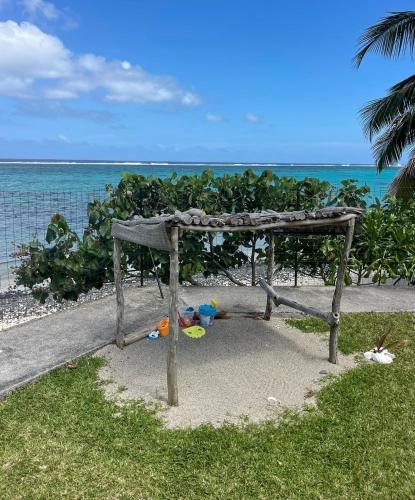 a picnic table on the beach next to the ocean at PK 35 in Apomaoro