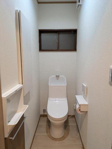 a small bathroom with a toilet and a sink at お宿みとしる in Mito